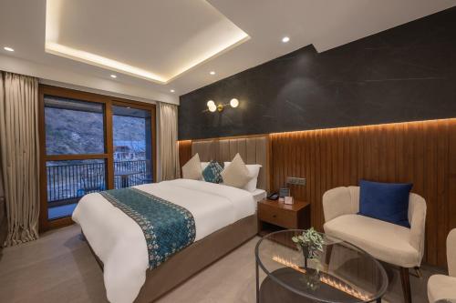 a bedroom with a bed and a chair and a window at Echor Noah Villa Tirthan Valley in Gushaini