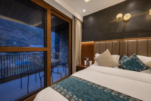 a bedroom with a bed and a balcony at Echor Noah Villa Tirthan Valley in Gushaini