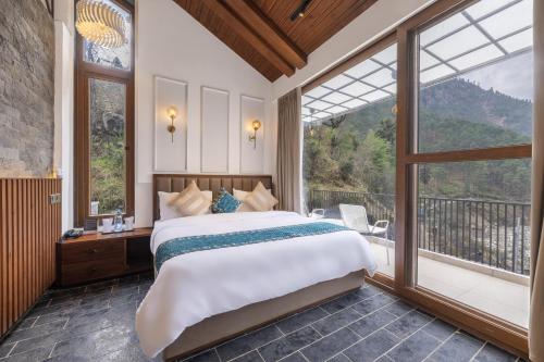 a bedroom with a large bed and a large window at Echor Noah Villa Tirthan Valley in Gushaini
