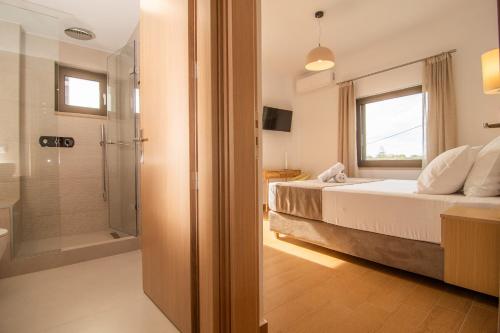 a bedroom with a bed and a glass shower at Diktamo apartment, Palaiochora in Palaiochóra