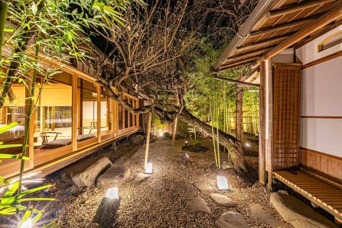 a house with a tree in the middle of a yard at プライベートリゾート竹泉 in Atami
