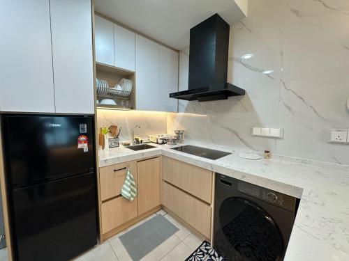 a kitchen with a black refrigerator and a dishwasher at Seri Kembangan Metacity, Cikgu Kabinet Empire, Equine Park,MRT Station, IOI mall, Putrajaya, Cyberjaya, Farm in the city, Uptown Equine in Seri Kembangan