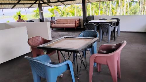 a group of chairs and tables in a room at mountain lake view private pool villa -Wayanad in Meppādi