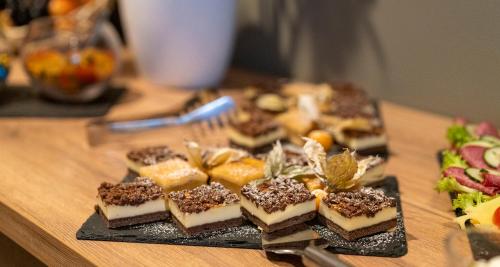 a plate of desserts on a wooden table at Sure Hotel by Best Western Hilden-Düsseldorf in Hilden