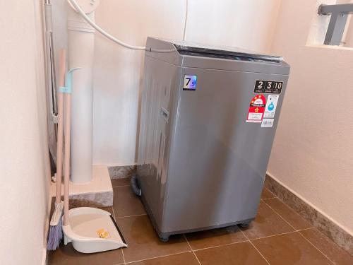 a small metal machine in a bathroom next to a toilet at R&F Seine Region in Johor Bahru