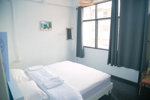 a white room with a bed and a window at Before We Go Hostel Donmueang in Ban Ko