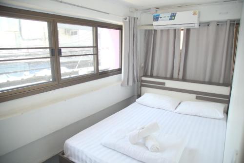 a small room with a bed with a window at Before We Go Hostel Donmueang in Ban Ko