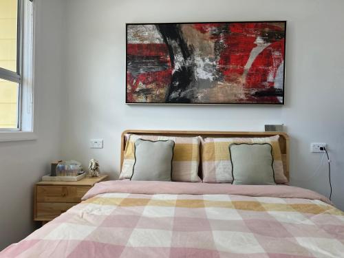 a bedroom with a bed and a painting on the wall at Private Room in Kawakawa