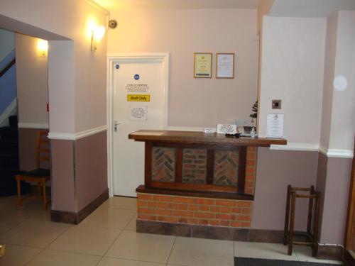 a room with a table and a clock on the wall at Gainsborough Lodge in Horley