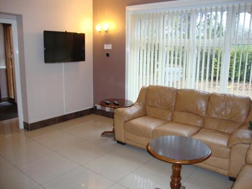 a living room with a couch and a coffee table at Gainsborough Lodge in Horley