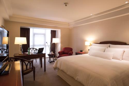 a hotel room with a large bed and a desk at Swissotel Lima in Lima