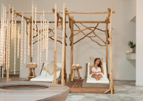 a woman sitting in a bed in a room at Elements Of Byron in Byron Bay