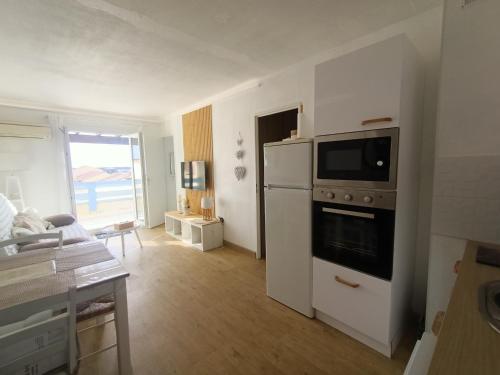 une cuisine avec une cuisinière et un micro-ondes dans l'établissement Beau T2 Climatisé avec Terrasse et Parking - FR-1-799-49, au Barcarès