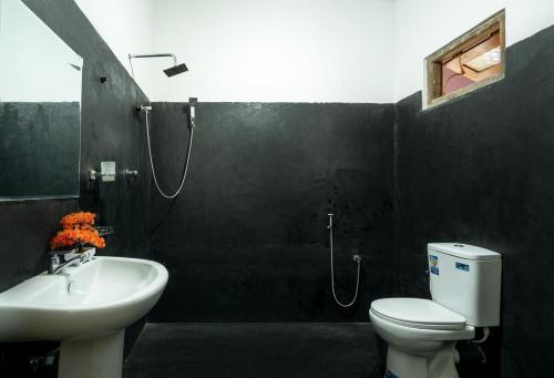 a bathroom with a sink and a toilet and a shower at Diyaluma NAS Villa in Koslanda