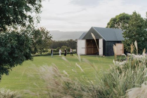 a group of people standing in front of a barn at Linnaeus Farm, Berry - by Linnaeus Collection in Berry