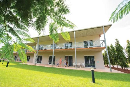 a building with two people standing on the balcony at Club Tropical Resort Darwin in Darwin