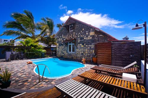 ein Swimmingpool vor einem Haus in der Unterkunft Rustic Balinese Villa in Grand Baie