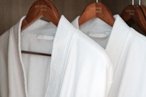 a group of white shirts hanging on a rack at Hotel Jeonju Hanok Village in Jeonju
