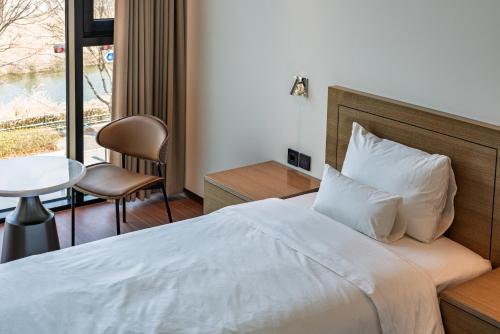 a hotel room with a bed and a table and chairs at Hotel Jeonju Hanok Village in Jeonju