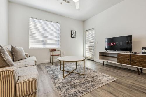 Una sala de estar con un sofá y un televisor. en CozySuites Glendale by the stadium with pool 22, en Glendale
