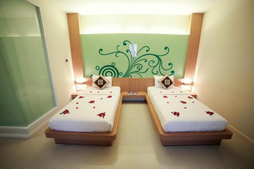 2 aparte bedden in een kamer met een groene muur bij Lanexang Princess Hotel in Vientiane