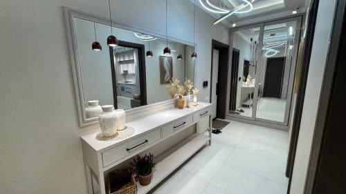 a bathroom with a vanity with a large mirror at TV Tower View Apartment in Yunusobod