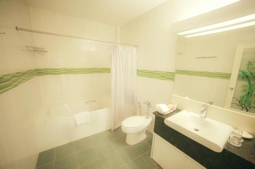 a white bathroom with a toilet and a sink at Lanexang Princess Hotel in Vientiane