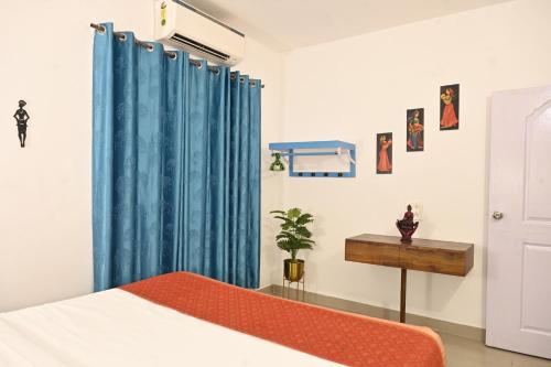 a bedroom with a bed and a blue curtain at Siolim 6bhk Private Villa with Private Pool close to Anjuna Vagator in Siolim