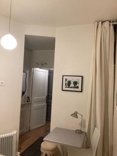 une chambre avec une table et une lampe sur un mur dans l'établissement Cosy and central, à Paris