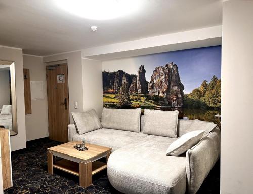 a living room with a couch and a painting on the wall at Gästehaus am Kurpark Hotel Garni in Horn-Bad Meinberg
