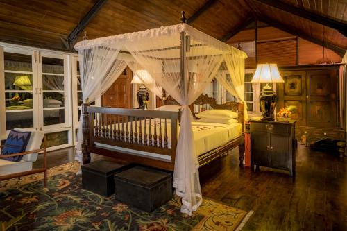 a bedroom with a bed with a canopy at Madulkelle Tea and Eco Lodge in Kandy