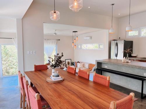 El PlantelにあるCasa Kaiyo - Luxury Jungle Beach Villa with ACの木製のテーブルと椅子のあるキッチンとダイニングルーム