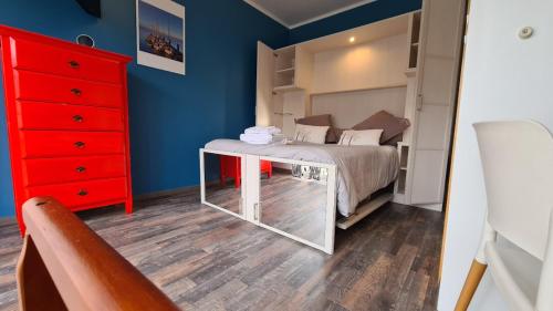 a bedroom with a bed and a red dresser at Appart Hôtel Le Ptit Bec in Bègles