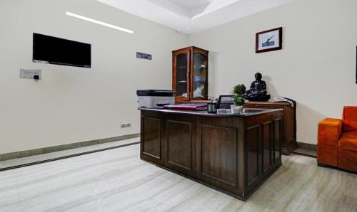 una oficina con escritorio y TV en una habitación en ICY White HM Stay Haven, en Noida