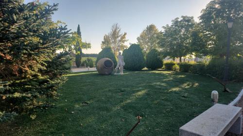 a person standing in a garden with a large sculpture at Finca el descanso manchego in Fuente de Pedro Naharro