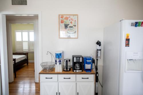 a kitchen with a counter with a coffee maker and a refrigerator at Historic, Family-Friendly Home in Downtown in Bakersfield