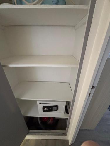 a closet with white shelves and a drawer at Gîte des hallettes in Fécamp