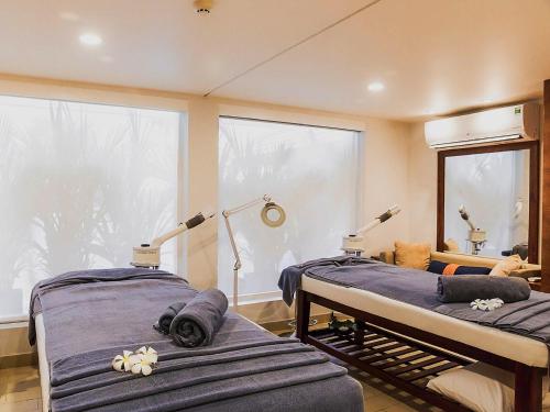 two beds in a room with a large window at Villa Song Saigon in Ho Chi Minh City