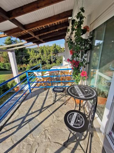 a patio with chairs and tables on a porch at Aelia House Chalkidiki in Fourka