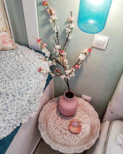 a vase with flowers on a table in a bedroom at Aelia House Chalkidiki in Fourka