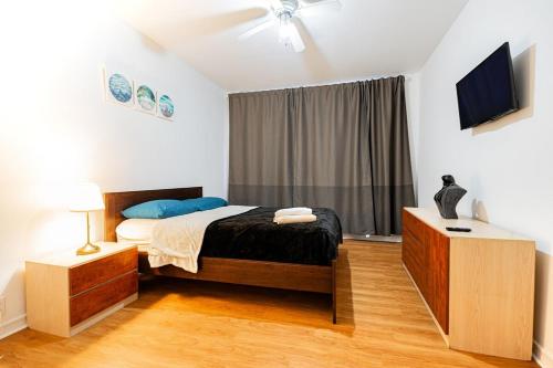 a bedroom with a bed and a television in it at Superbe appartement près McGill in Montréal