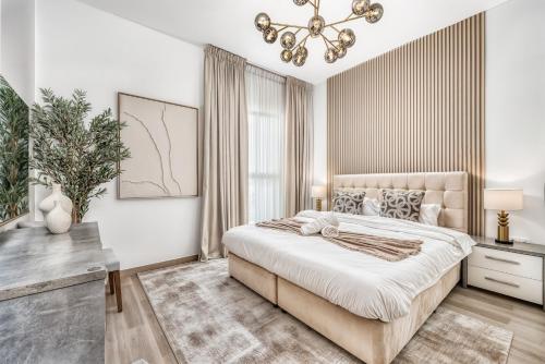 a bedroom with a large bed and a chandelier at Luxury 2BR, Yas Island by Ferrari World & Yas Mall in Abu Dhabi