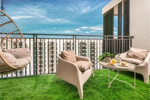 a balcony with two chairs and a table on the grass at Luxury 2BR, Yas Island by Ferrari World & Yas Mall in Abu Dhabi
