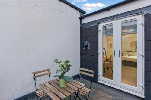 a patio with a wooden bench and a sliding glass door at Stylish 2BR Clerkenwell Apartment Private Outdoor Space in London
