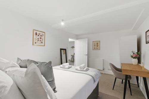 a white bedroom with a bed and a desk at Stylish 2BR Clerkenwell Apartment Private Outdoor Space in London
