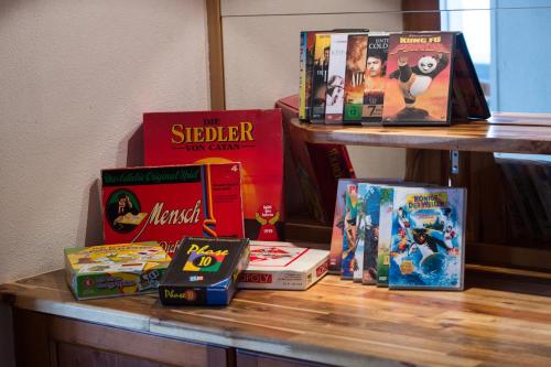 a shelf filled with books on a table at Panoramagasthof auf dem Auerberg in Bernbeuren
