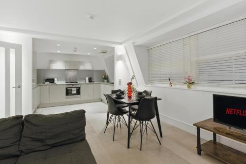 a kitchen and living room with a table and chairs at Stylish 2BR Clerkenwell Apartment Private Outdoor Space in London