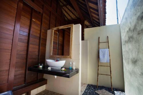 a bathroom with a sink and a mirror at Dinatah Lembongan Villas in Nusa Lembongan
