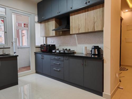 a kitchen with black cabinets and a counter top at Astonishing 3BHK at 6-Floor for Family only in Bengaluru