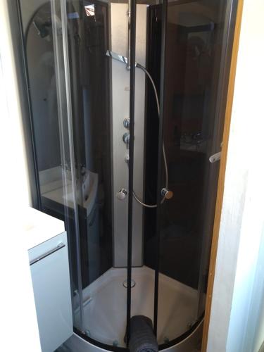 une douche avec une porte vitrée dans une salle de bain dans l'établissement superbe t3, à Cognac